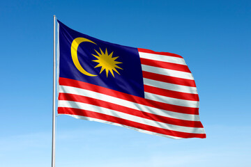 Waving Malaysia flag, national symbol, blue sky