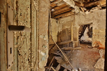 Ruine Werkstatt Zimmer zerstört, Decke eingebrochen,verwittert, mit großer 
Tür Holz, Türschloss  antik, Farbreste an Wand, mehrfarbig,
mit Blick anderes Zimmer, niemand, Deutschland Thüringen
Gera 