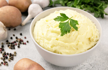 Mashed potatoes in white bowl on grey concrete background. Healthy food