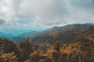 The stunning view of the sun set  from a tourist's standpoint with a foggy hill and a background of a golden sky in National Park, Thailand. Rainforest. Bird's eye view. Aerial view.