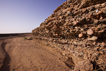Wadi , Stein Wand Relief Bauwerk aus gewaschen von Regen Flut, im Licht bei Sonne Untergang, Strand...