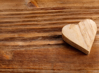 Light wooden heart on a dark wodden table