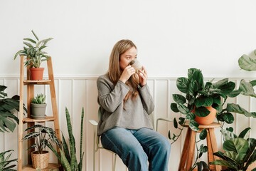 Plant lady resting and sipping tea in her plant corner