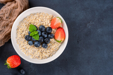 Milk porridge prepared for breakfast with blueberries, strawberries and bananas