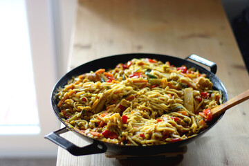 Bowl of stir fry vegetables and noodles, served on the table. Selective focus.