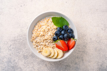 Milk porridge prepared for breakfast with blueberries, strawberries and bananas