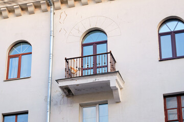 Damaged balcony support bracket and cracked plaster on the facade of residential building,...