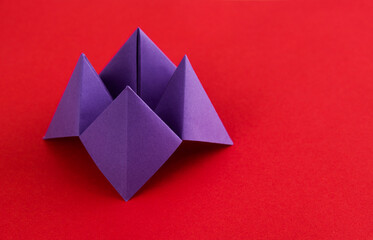 Origami paper fortune on red background