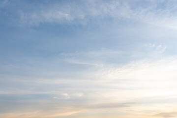 A breathtaking cloudscape unfolds across the vibrant blue summer sky, where fluffy white clouds drift lazily in the warm sunlight