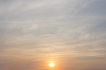 Golden hour paints the sky with vibrant hues as the sun descends, casting a fiery glow on the clouds