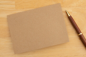 Blank greeting card with pen on wooden table