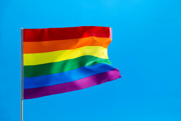 Rainbow flag waving on blue background