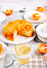 Glass of fresh lemonade and orange cake with fruit citrus slices.
