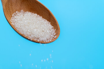 Sugar crystals falling out of wooden spoon