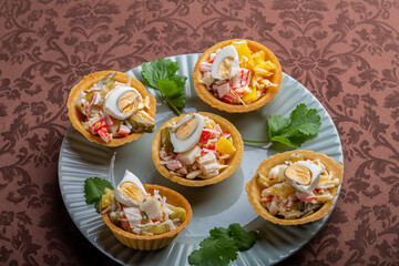 Salad with pineapples and tarts on a plate decorated with cilantro