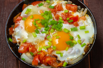 Shakshuka Jewish dish with egg and spicy tomatoes and green onions