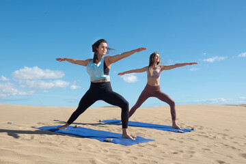Fototapeta premium women doing yoga and stretching exercises on the beach 