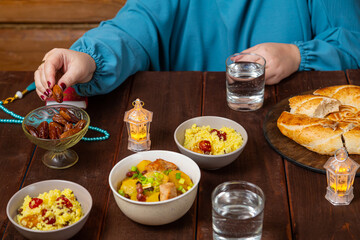 Muslim woman with hand at table eating date iftar Ramadan