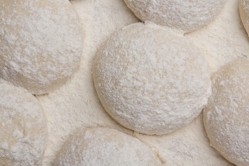 Massa de pão e pizza espelhadas com farinha, tudo numa mesa de pizzaollo