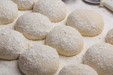 Massa de pão e pizza espelhadas com farinha, tudo numa mesa de pizzaollo