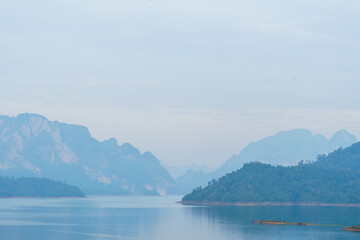Serene landscape with misty mountains and calm water reflections