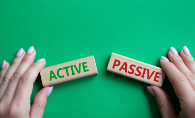 Active or Passive symbol. Concept word Active or Passive on wooden blocks. Businessman hand. Beautiful green background. Business and Active or Passive concept. Copy space