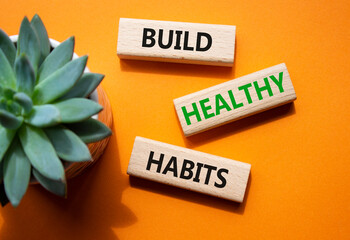 Healthy habits symbol. Concept word Build Healthy habits on wooden blocks. Beautiful orange...