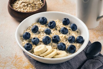 Milk porridge prepared for breakfast with blueberries, strawberries and bananas