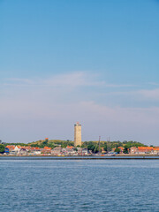 Obraz premium Skyline of West-Terschelling harbor and Brandaris lighthouse on West Frisian island Terschelling from Waddensea, Friesland, Netherlands