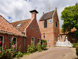 Streetscene with detached churchtower of Reformed Church in Ezinge, Westerkwartier, Groningen