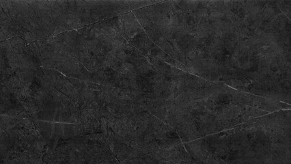 A black and white photo of a wall with a rough texture. The photo has a moody and dramatic feel to it