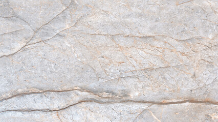 A white and gray marble wall with a pattern of swirls and lines. The wall is smooth and shiny, giving it a luxurious and elegant appearance. The pattern on the wall is reminiscent of a flowing river