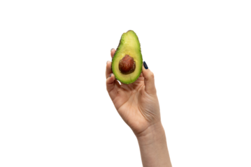 Close-up of a woman's hand holding a halved avocado with the pit exposed against a white background.