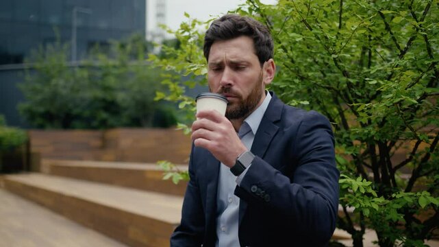 Dissatisfied businessman Caucasian business man male employer client drinking coffee tea outdoors city displeased upset worried frowning guy unpleasant disgust bad taste drink awful spoiled beverage