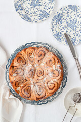 Home baked cinnamon rolls shot from above. Minimal styling flat lay with blue plates