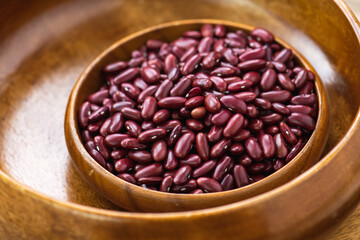 A wooden bowl filled with red kidney beans.