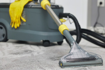 Professional wet and dry vacuum cleaner set up on a gray carpet, showing a scene of carpet cleaning...