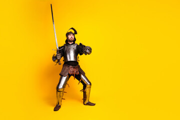 Knight in shining armor holding a sword against a vibrant yellow background