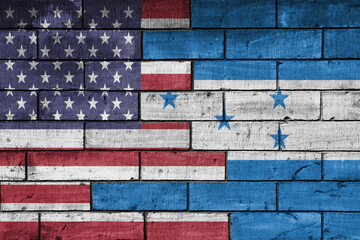 colourful painted big flag of united states of america and flag of honduras on a massive old brick...