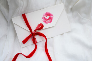 Love letter. white envelope with lipstick in the form of a kiss on a white background. Valentine's Day composition.