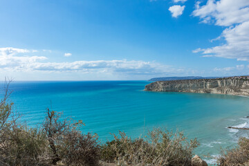 Fototapeta premium View of Zapallo Bay Beach in Cyprus: Azure Sea and Rocky Cliff on a Sunny Day