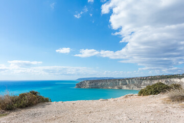 View of Zapallo Bay Beach in Cyprus: Azure Sea and Rocky Cliff on a Sunny Day