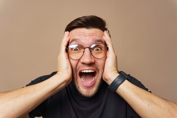 Excited man expressing joy with hands on face in a neutral background during a happy moment