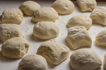 Massa de pão e pizza na farinha na mesa do Pizzaiollo prontas para se transformarem em pizza e pão