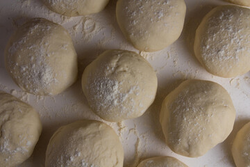 Massa de pão e pizza na farinha na mesa do Pizzaiollo prontas para se transformarem em pizza e pão