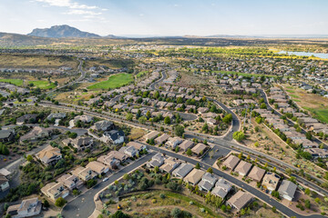 Residential neighborhood view showcasing houses, streets, and open land in a mountainous area during daytime