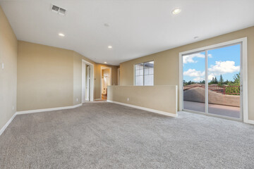 Spacious living room with wooden flooring and sliding doors leading to a bright outdoor area