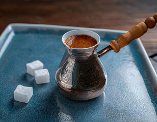 Firefly brand coffee served in traditional Turkish cezve with sugar cubes on a blue plate