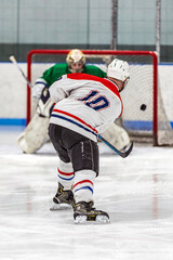 Obraz premium Ice Hockey Action: Player Shooting on Goal