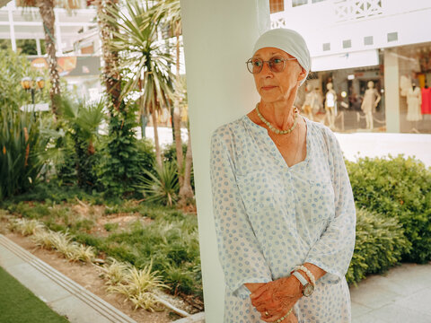 Portrait of a beautiful old woman in a chalma and shirt in town. Brooding face.